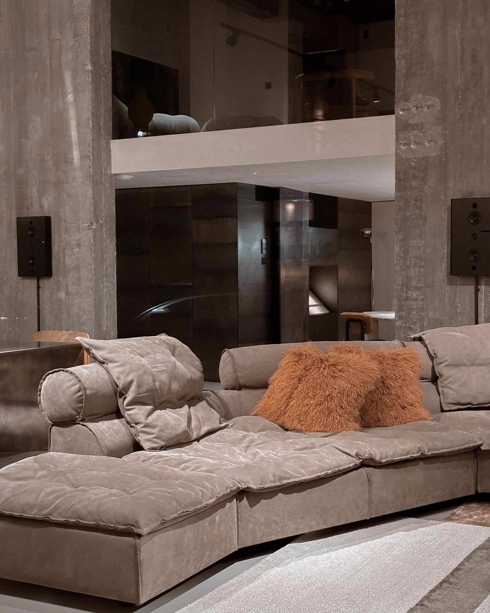 Sala de concreto con altavoces arquitectónicos empotrados