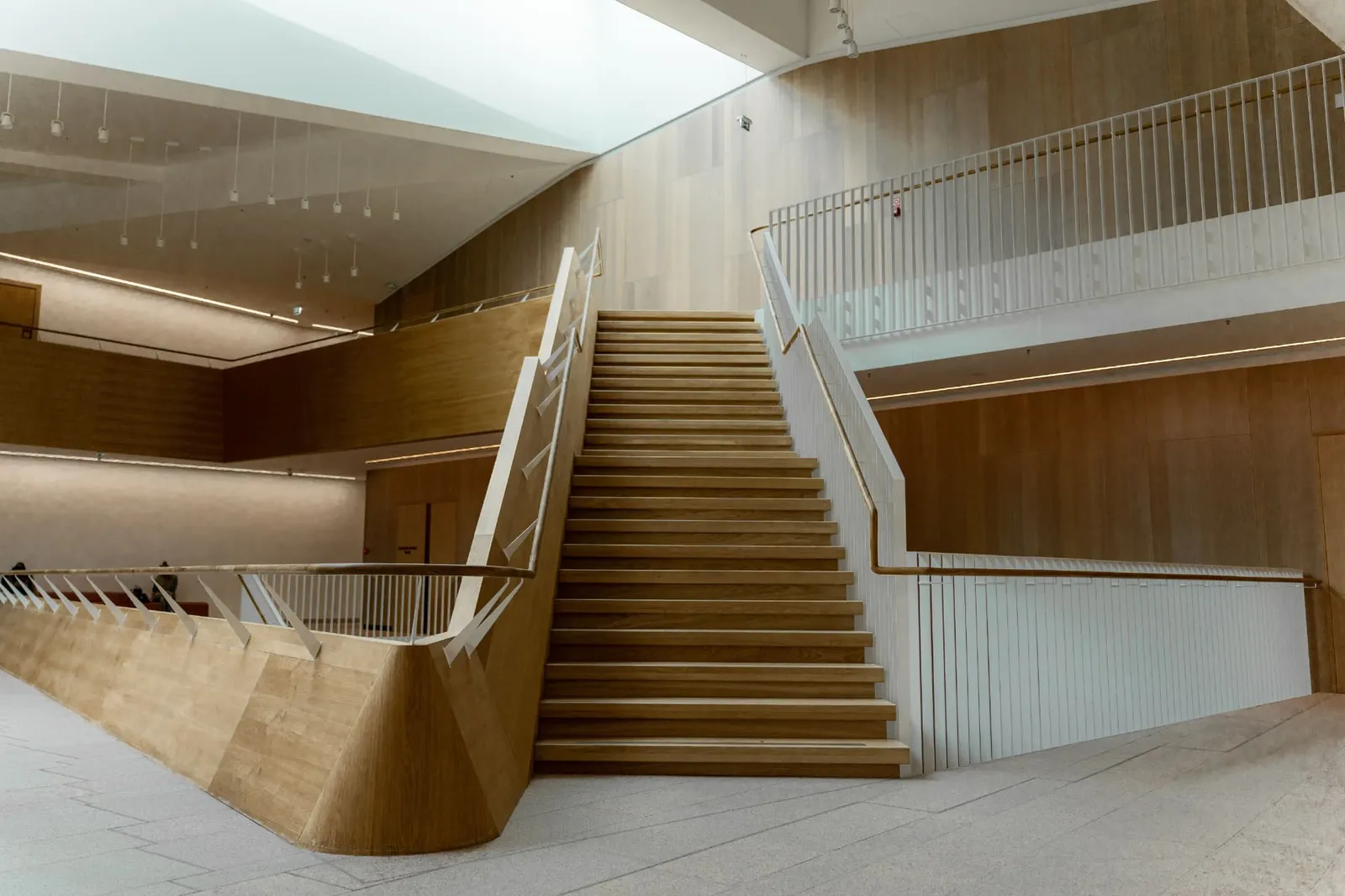 Escalera de madera en un espacio de doble altura con luz natural